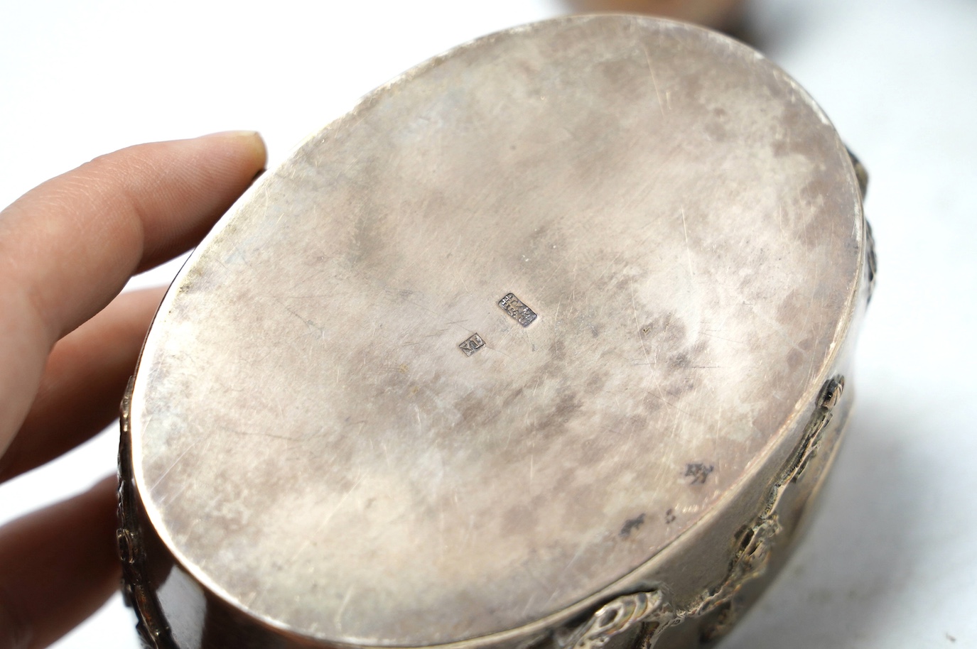 An early 20th century Japanese oval white metal box and associated? cover, 10.2cm, together with a similar posy vase, jar without cover and three mounted clothes brushes. Condition - fair to poor